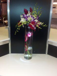 Tall lit glass vase with purple flowers