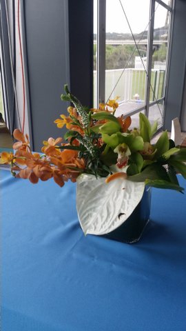 Table arrangement, with large leaf and orange flowers