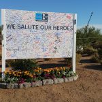 Flowers beneath a sign honoring heros